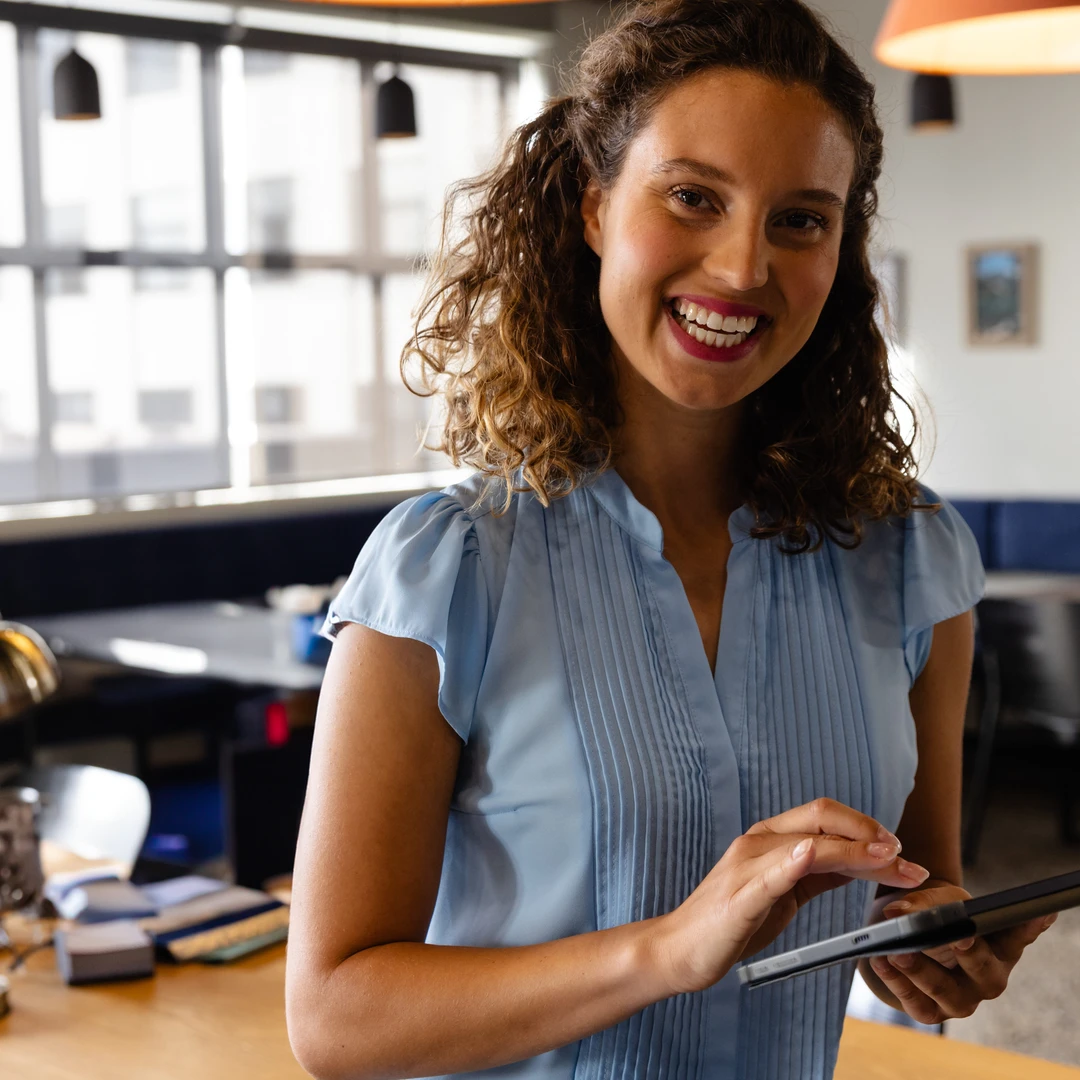 Female professional with curly hair using digital tablet at workplace