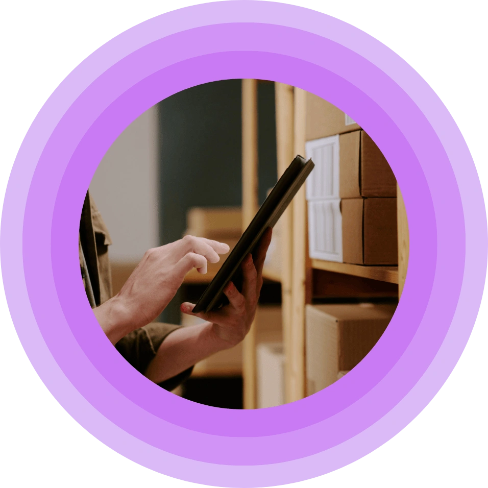man pressing his tablet in a storage room.